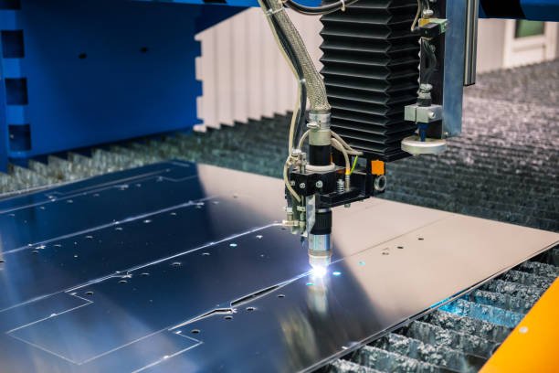 close up of laser cutting machinery cutting aluminum sheet at industrial plant